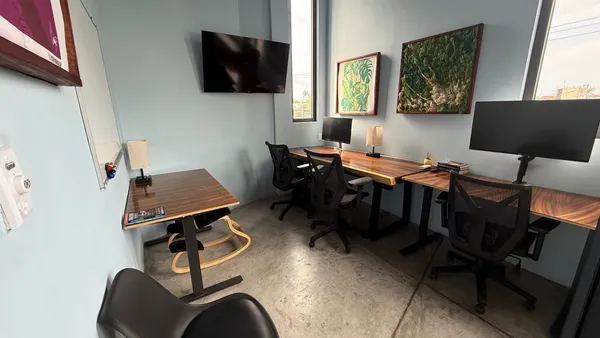 Una oficina privada, moderna y luminosa, con una gran ventana, una silla cómoda y un escritorio espacioso.