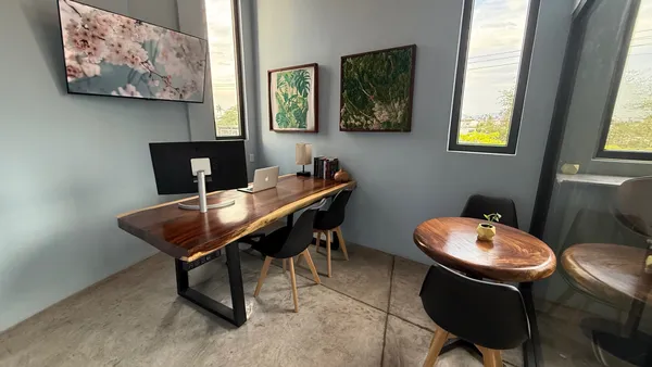 A bright and modern private office with a large window, a comfortable chair, and a spacious desk.