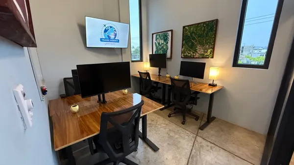 A bright and modern private office with a large window, a comfortable chair, and a spacious desk.